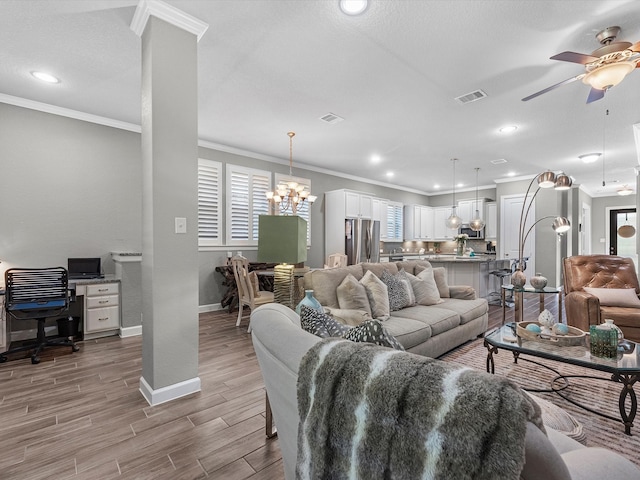 living room featuring a textured ceiling, crown molding, light hardwood / wood-style floors, and ceiling fan with notable chandelier