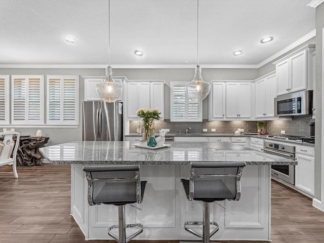 kitchen featuring pendant lighting, appliances with stainless steel finishes, and a center island