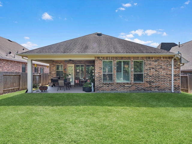 back of property with a lawn and a patio