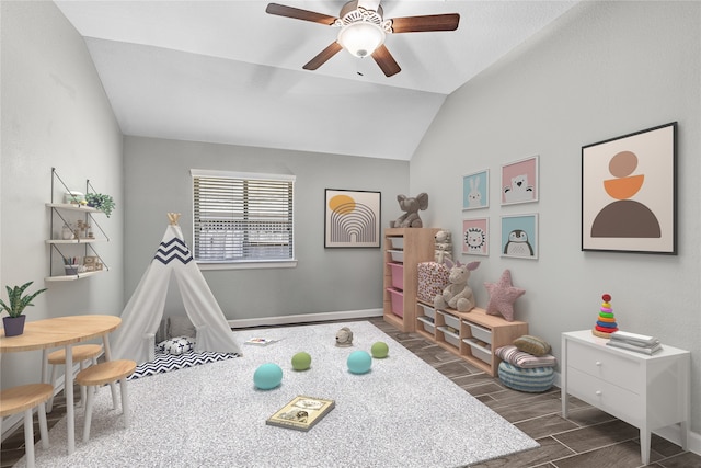 playroom with dark hardwood / wood-style flooring, vaulted ceiling, and ceiling fan