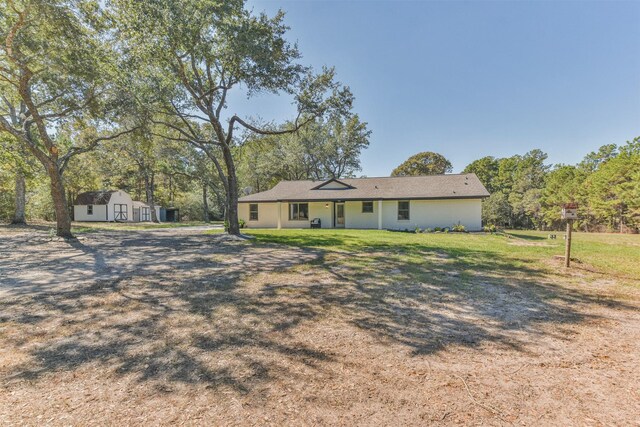 view of front of property with a shed and a front lawn