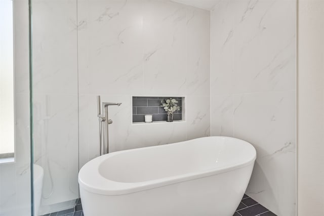 bathroom featuring a tub and tile walls