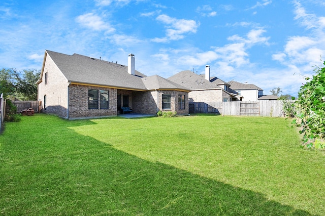 rear view of property with a patio area and a yard