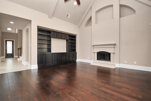 unfurnished living room with hardwood / wood-style floors, ceiling fan, high vaulted ceiling, and built in shelves