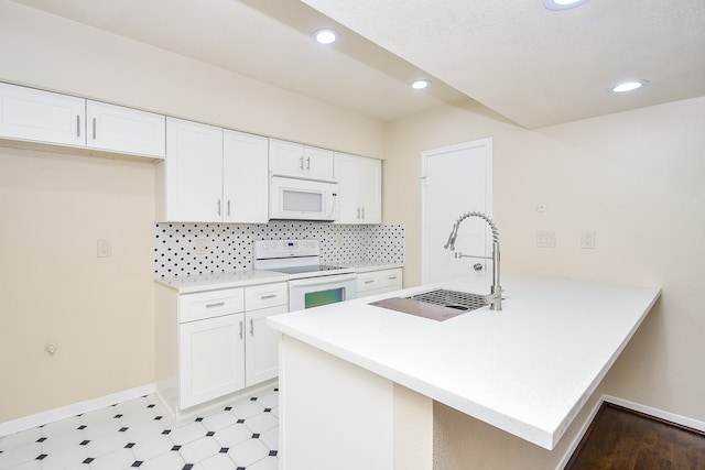 kitchen with kitchen peninsula, white cabinets, backsplash, sink, and white appliances