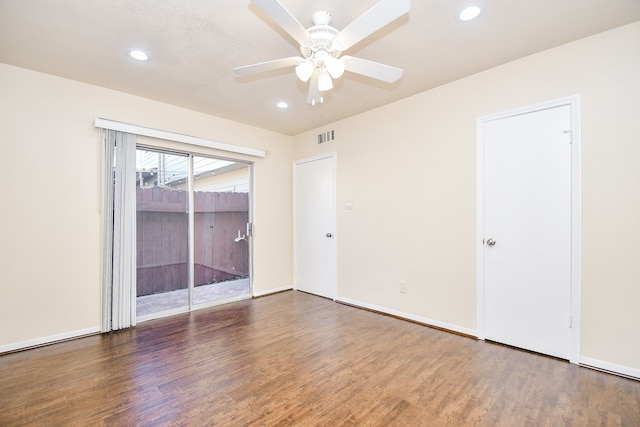 spare room featuring dark wood-type flooring and ceiling fan