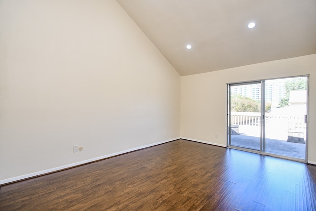 empty room featuring high vaulted ceiling and dark hardwood / wood-style flooring