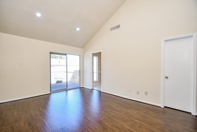 empty room featuring dark wood-type flooring and high vaulted ceiling