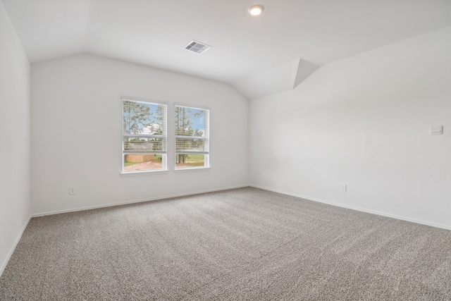 carpeted spare room featuring lofted ceiling