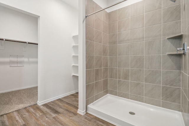 bathroom with wood-type flooring and tiled shower