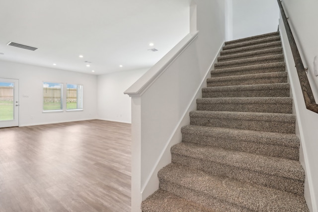 stairs featuring hardwood / wood-style flooring