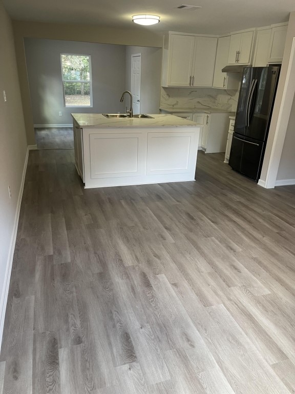 kitchen with sink, white cabinets, fridge, and hardwood / wood-style flooring