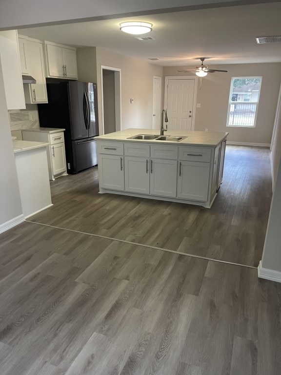 kitchen with white cabinetry, sink, dark wood-type flooring, and an island with sink