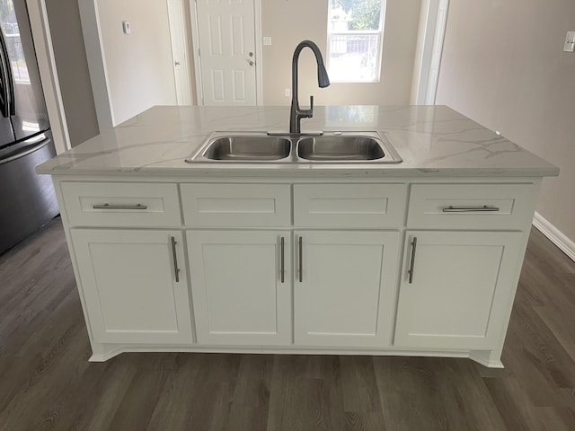 kitchen featuring white cabinetry, stainless steel fridge, light stone countertops, and sink