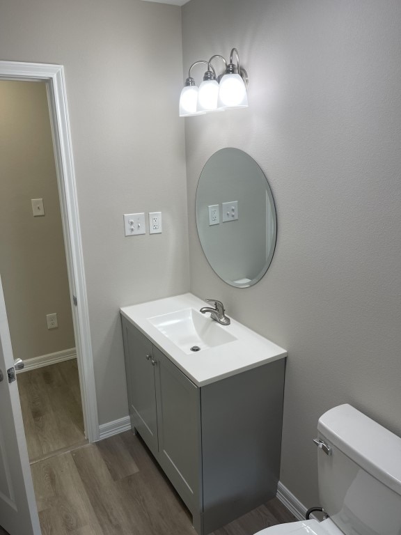 bathroom featuring vanity, toilet, and wood-type flooring