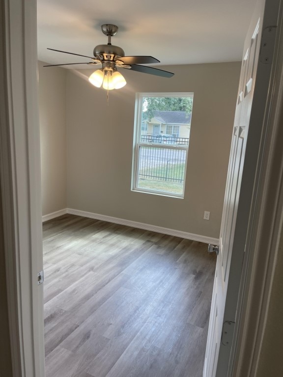 empty room with light wood-type flooring and ceiling fan