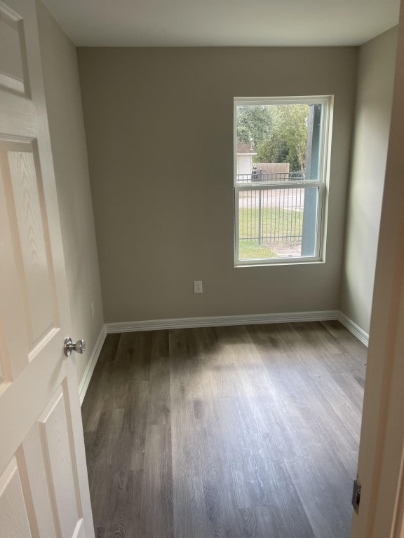 unfurnished room with dark hardwood / wood-style flooring