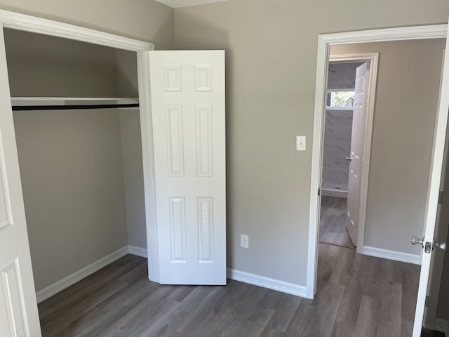 unfurnished bedroom featuring a closet and dark hardwood / wood-style floors