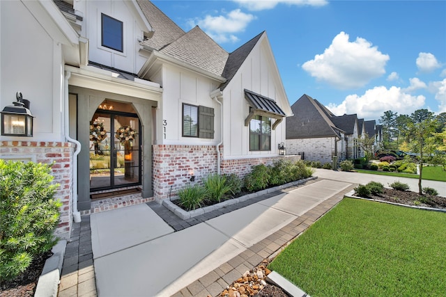 view of exterior entry featuring a lawn