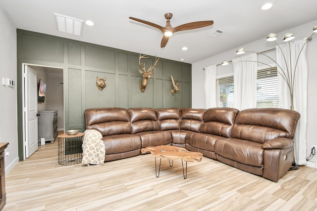 living room featuring light hardwood / wood-style floors and ceiling fan