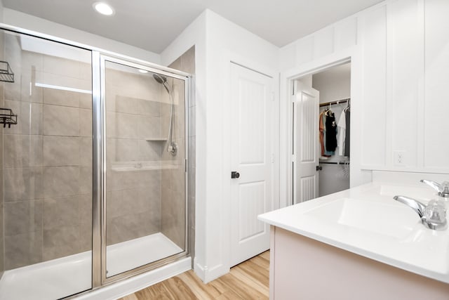 bathroom featuring wood-type flooring, vanity, and a shower with door