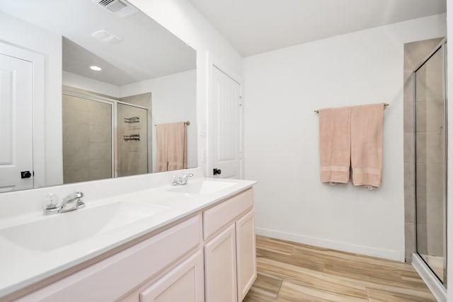 bathroom with hardwood / wood-style flooring, vanity, and walk in shower