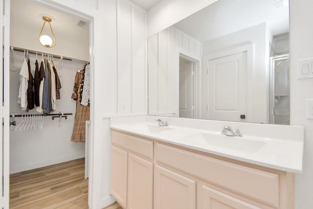 bathroom with walk in shower, vanity, and hardwood / wood-style flooring