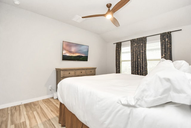 bedroom featuring light hardwood / wood-style floors, ceiling fan, and vaulted ceiling