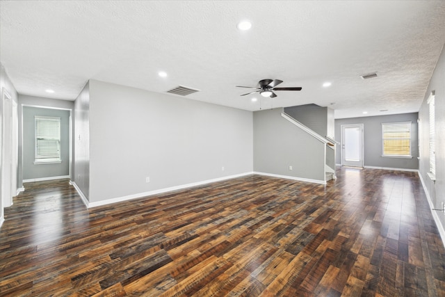 unfurnished living room with a textured ceiling, ceiling fan, and dark hardwood / wood-style flooring