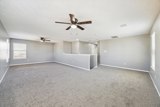 empty room featuring a textured ceiling, carpet floors, and ceiling fan