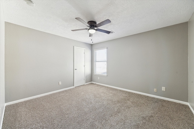 spare room featuring a textured ceiling, carpet flooring, and ceiling fan