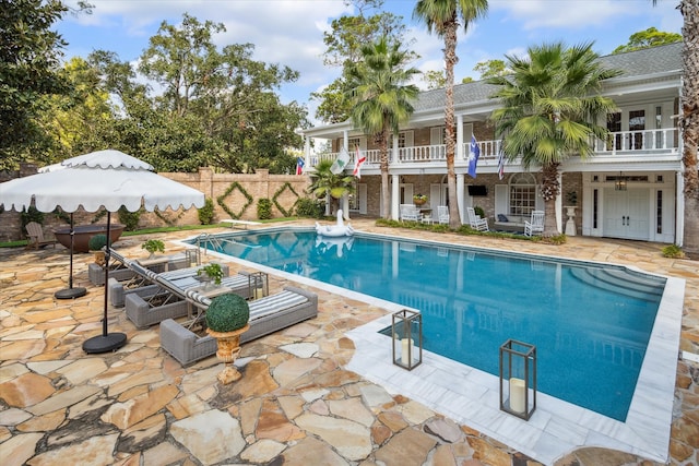 view of pool with a patio area and a diving board