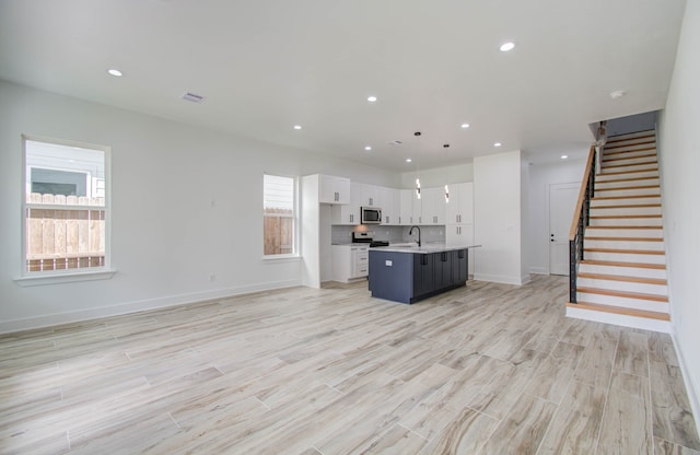 unfurnished living room featuring light hardwood / wood-style floors and sink