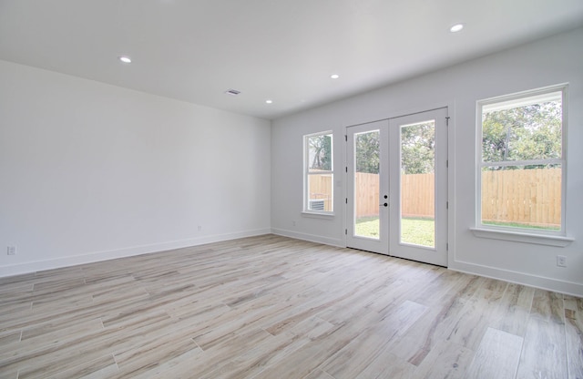 spare room with french doors and light wood-type flooring