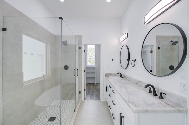 bathroom featuring vanity, wood-type flooring, and a shower with door