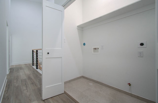 washroom featuring hookup for a gas dryer, light hardwood / wood-style flooring, washer hookup, and electric dryer hookup