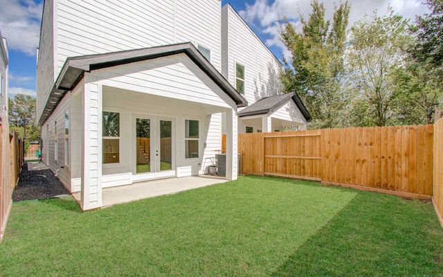 back of house with french doors and a yard