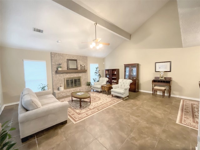 living room featuring ceiling fan, a healthy amount of sunlight, beamed ceiling, and a brick fireplace