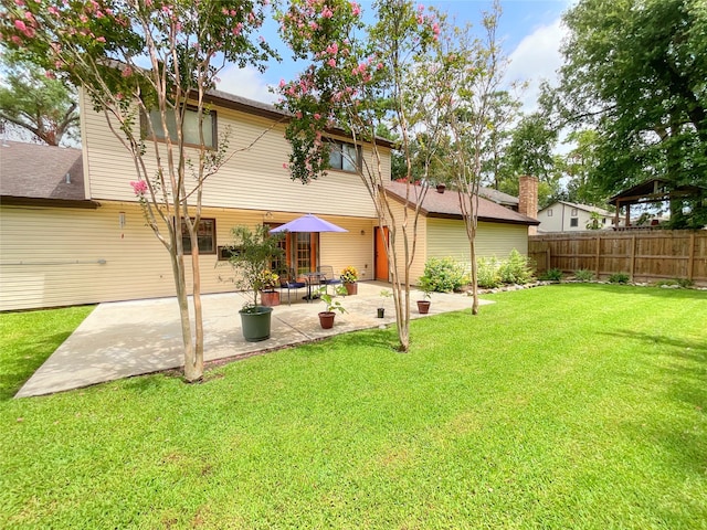 back of property featuring a patio and a yard