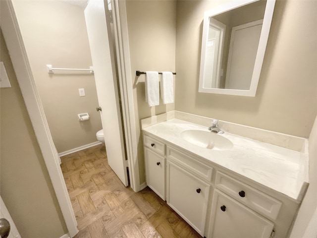 bathroom with vanity, toilet, and hardwood / wood-style floors