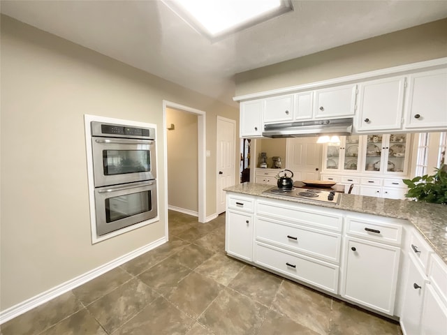 kitchen featuring light stone countertops, appliances with stainless steel finishes, and white cabinets