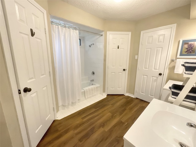 bathroom with vanity, a textured ceiling, shower / tub combo with curtain, and hardwood / wood-style flooring