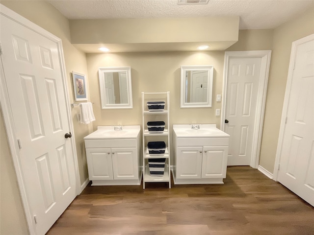 bathroom featuring vanity, a textured ceiling, and wood-type flooring