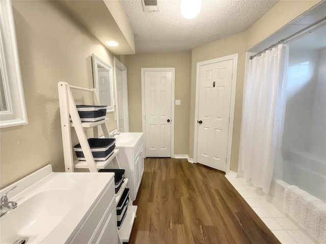 bathroom featuring vanity, wood-type flooring, and a textured ceiling