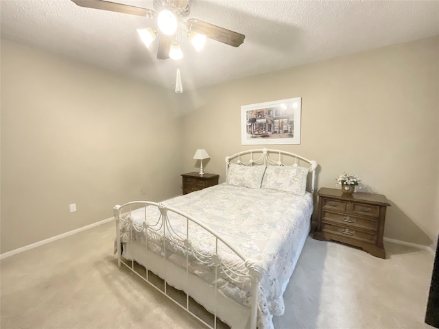 bedroom featuring ceiling fan, a textured ceiling, and light colored carpet