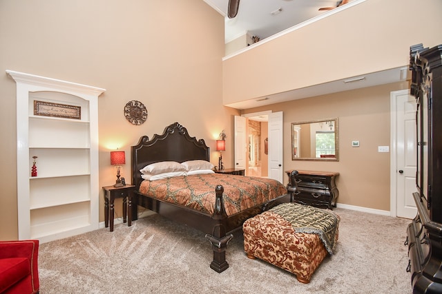 bedroom with ceiling fan, carpet flooring, and a high ceiling