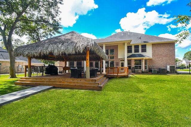 back of property featuring a gazebo, central AC, a deck, and a lawn