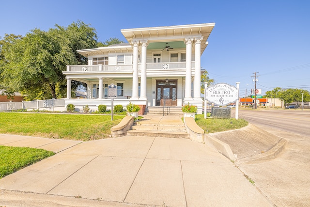 view of front of home featuring a balcony, a front yard, ceiling fan, and a porch