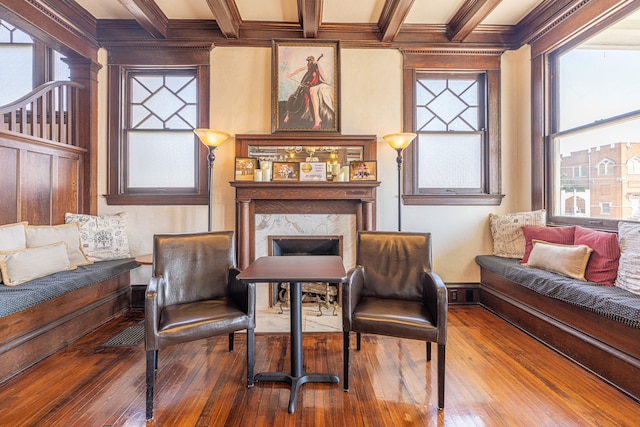 sitting room with beam ceiling, a high end fireplace, coffered ceiling, and wood-type flooring