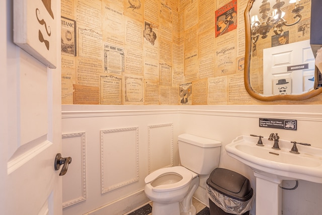 bathroom featuring an inviting chandelier and toilet